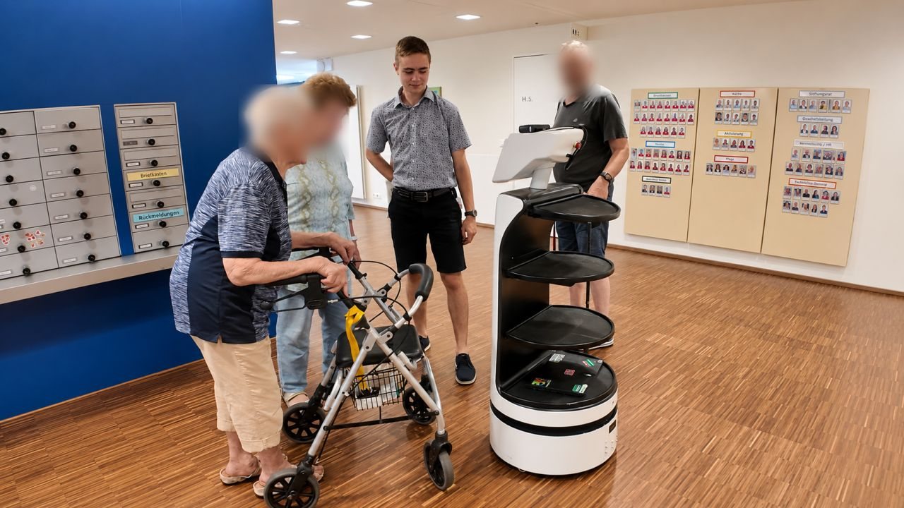 Residents and staff gathered around the robot in the Haus Tabea lobby